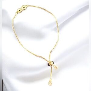 Gold tone infinity sliding stopper bracelet with two charms and crystals
